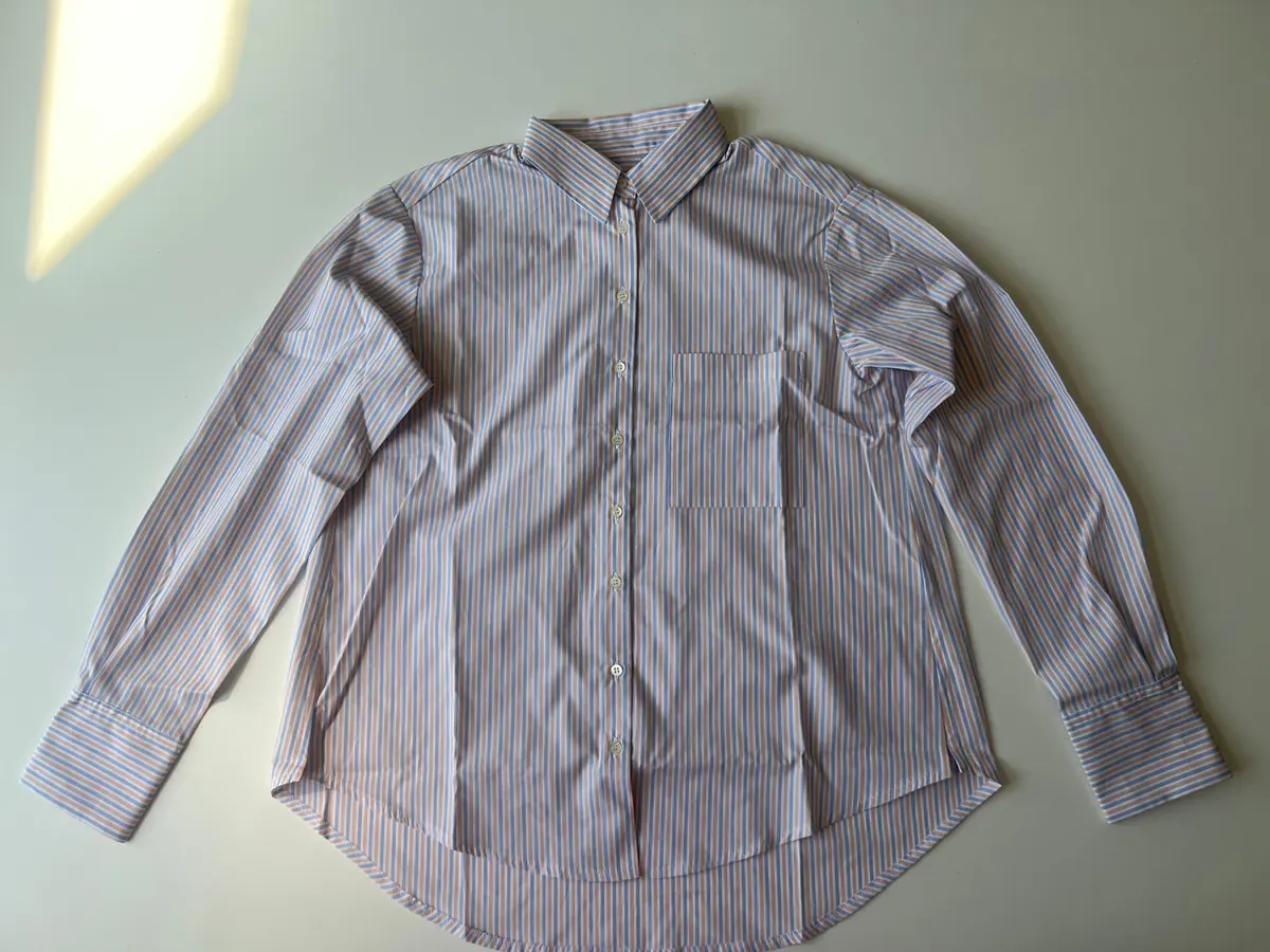 A phone photo of a striped shirt laid flat on a table
