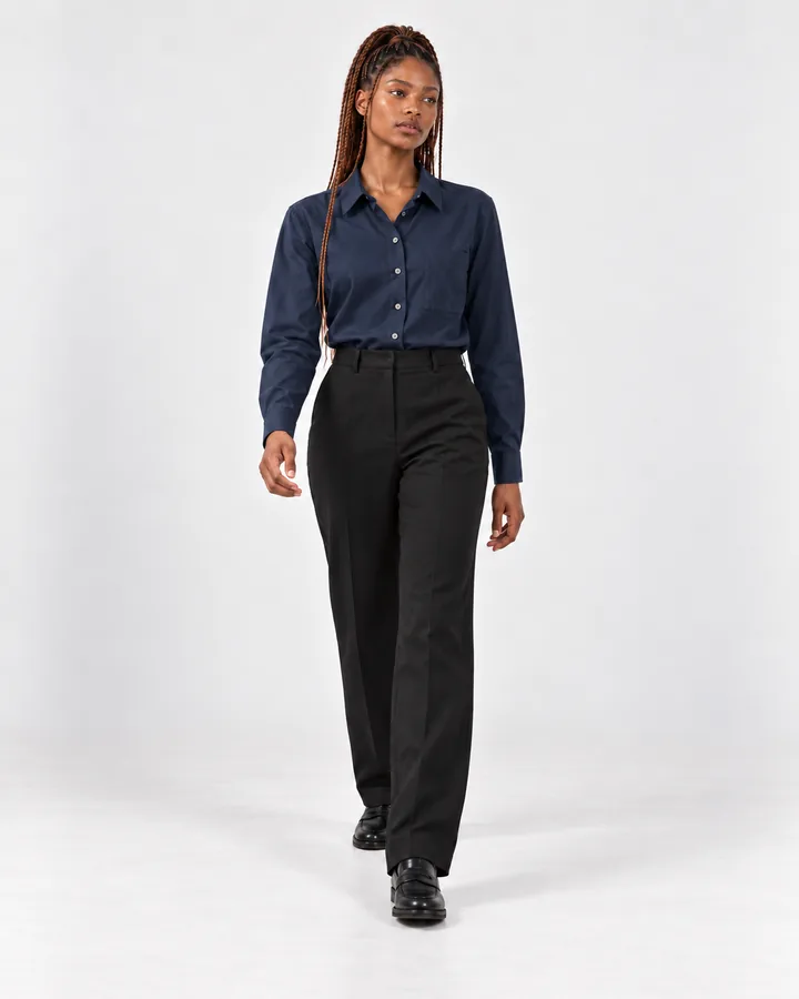 Ready-made model Zola walking in a navy shirt and black trousers, looking off to the side